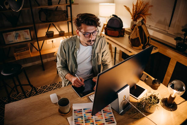 young handsome man working late at night in his home office